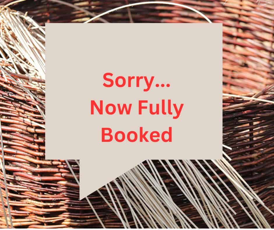 A sign with the text "sorry... now fully booked for free session" in red lettering displayed against a background of woven wicker.